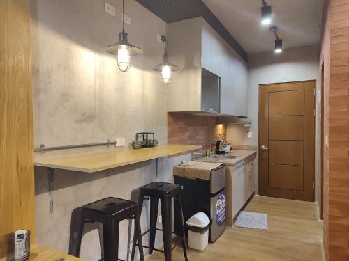 a kitchen with a counter and some stools in it at The Zen Suites at Mesatierra Garden Residences in Davao City