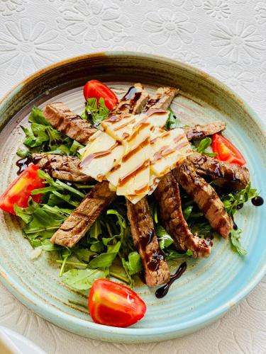 a plate of food with meat and salad on a table at Kompleksi Turistik DEA in Shkodër