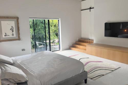 um quarto com uma cama e uma televisão de ecrã plano em One Park Lane em Southwell