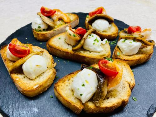 a blue plate with four pieces of toast with cheese and tomatoes at Kompleksi Turistik DEA in Shkodër