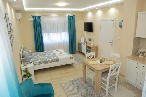 a small room with a bed and a table and chairs at Vila Harmony in Pirot