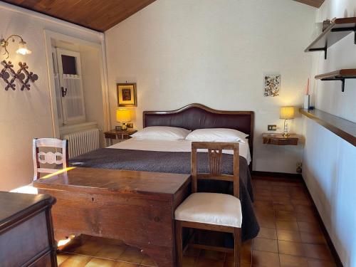 sypialnia z łóżkiem, stołem i krzesłami w obiekcie Ester Lakehouse, graziosa casa indipendente w mieście Lierna