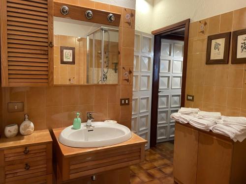 W łazience znajduje się umywalka i lustro. w obiekcie Ester Lakehouse, graziosa casa indipendente w mieście Lierna
