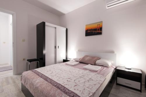 1 dormitorio con 1 cama grande y una pintura en la pared en La Mer Luxury Apartments, en Golden Sands