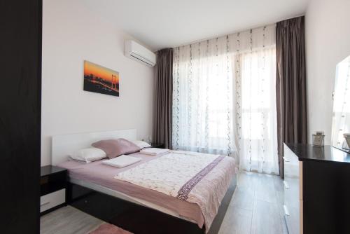una camera con un letto e una grande finestra di La Mer Luxury Apartments a Golden Sands