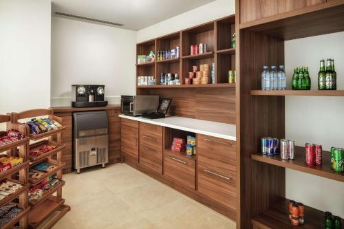 a kitchen with wooden shelves and a counter with drinks at Hilton Garden Inn Al Jubail in Al Jubail