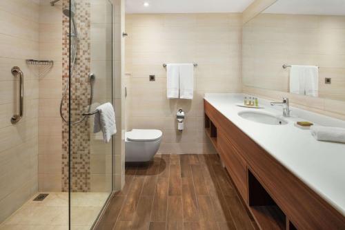 ein Bad mit einem WC, einem Waschbecken und einer Dusche in der Unterkunft Hilton Garden Inn Al Jubail in Al-Dschubail