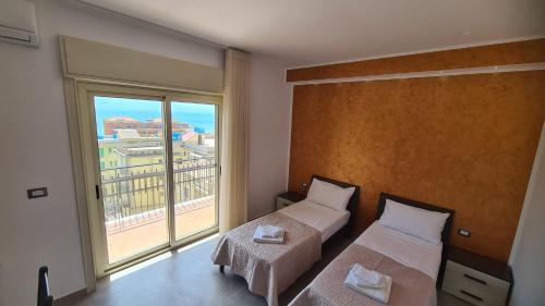 1 dormitorio con 2 camas y ventana grande en CASA VENEZIANO, en Messina