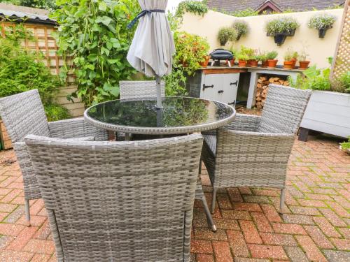 a table and chairs with an umbrella on a patio at The Shippen in Bude