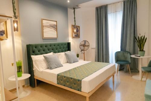BARI SUPPA _ Terrace & Garden _ في باري: غرفة نوم مع سرير مع اللوح الأمامي الأخضر