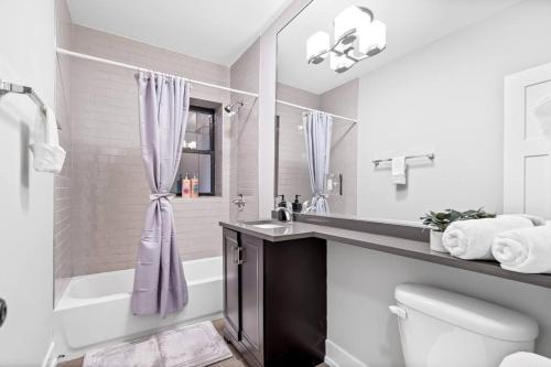a bathroom with a sink and a toilet and a shower at 1-bedroom Chic Apartment with Laundry - Brompton 55-57 rep in Chicago
