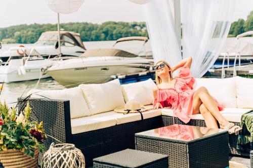 a woman sitting on a couch on a boat at Hotel Ukiel Wellness & SPA in Olsztyn