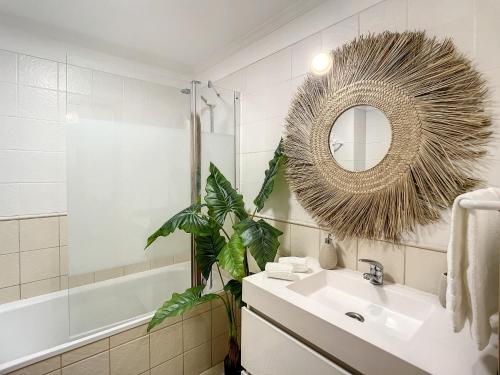 La salle de bains est pourvue d'un lavabo, d'un miroir et d'une plante. dans l'établissement Sea & Mountain by Atlantic Holiday, à Funchal