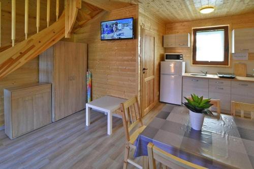 a kitchen with a table and a refrigerator in a cabin at Comfortable holiday homes Mielno in Mielno