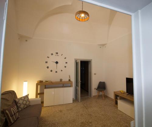 a living room with a clock on the wall at Casa Vacanze in Salento A casa di Benedetta in Squinzano