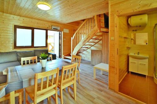 a dining room and living room with a wooden house at Comfortable holiday homes Mielno in Mielno