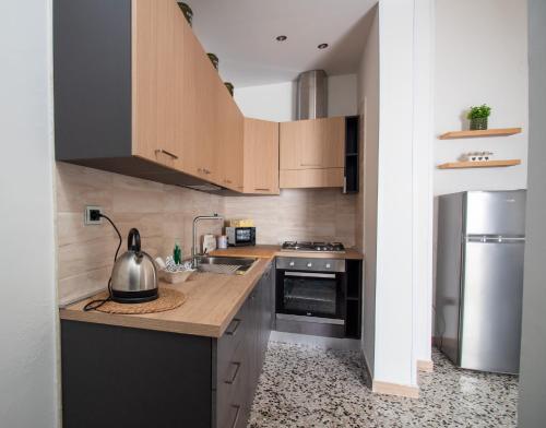 a kitchen with wooden cabinets and a stainless steel refrigerator at Casa Vacanze in Salento A casa di Benedetta in Squinzano