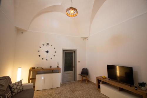 a living room with a clock on the wall and a tv at Casa Vacanze in Salento A casa di Benedetta in Squinzano