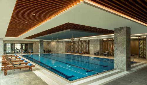a large swimming pool in a building at DoubleTree by Hilton Manisa in Manisa