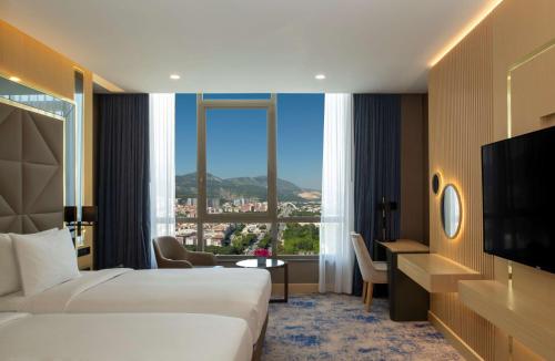 a hotel room with two beds and a large window at DoubleTree by Hilton Manisa in Manisa