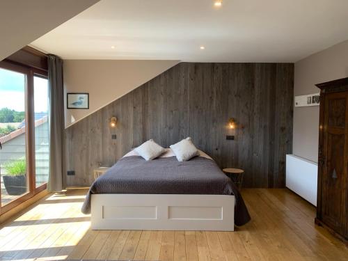 a bedroom with a bed and a wooden wall at La Ferme Des Eglantines in Nivelles
