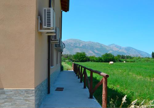 a building with a walkway next to a field at Agriturismo I 3 Fratelli in Sala Consilina