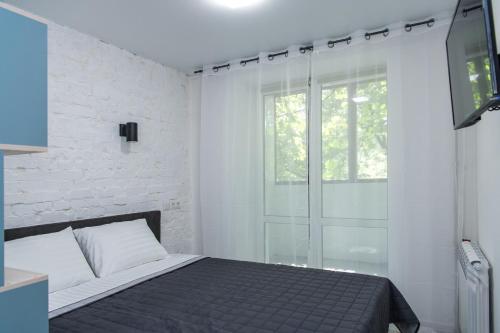 um quarto com uma cama e uma porta de vidro deslizante em MYFREEDOM Апартаменти метро Берестейська em Kiev