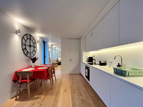 a kitchen and dining room with a red table and chairs at Nomads Lux - 2BDR Almada Private Porto in Porto