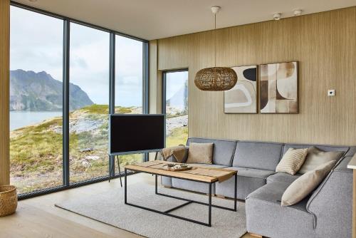 a living room with a couch and a tv at NEW! Lofoten Luxury Home near Henningsvaer in Lyngværet
