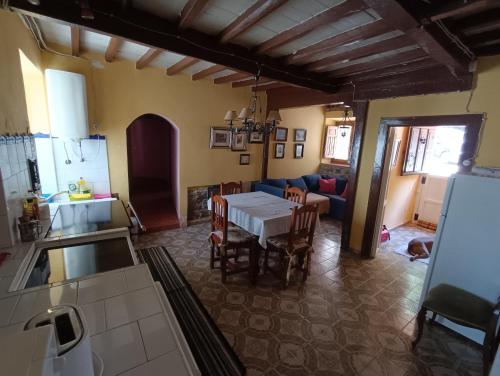 una cucina e un soggiorno con tavolo e sedie di Casa rural El Huerto. Las mascotas son bienvenidas a Soto del Barco