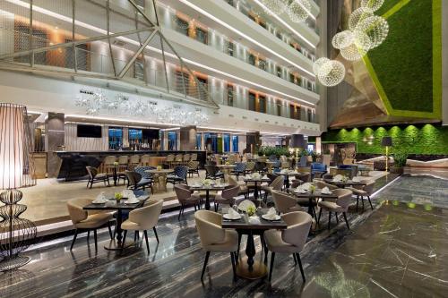 un restaurante con mesas y sillas en un edificio en DoubleTree by Hilton Istanbul - Piyalepasa, en Estambul