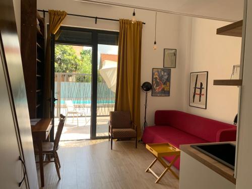 a living room with a red couch and a sliding glass door at Sunny studio apartment Chiara in Tivat
