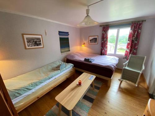 Zimmer mit 2 Betten und einem Tisch in der Unterkunft Little Guesthouse Cabin, Once Home to Lotta Svärd in Raasepori