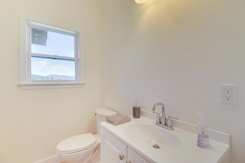 a bathroom with a toilet and a sink and a window at Mountain and Lake View Rexford Estate on 28 Acres! in Rexford
