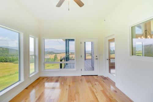 a living room with large windows and a ceiling fan at Mountain and Lake View Rexford Estate on 28 Acres! in Rexford