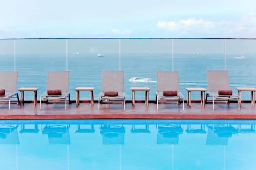 a group of chairs and tables next to a swimming pool at DoubleTree By Hilton Istanbul - Moda in Istanbul