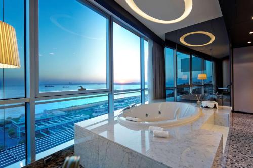 a bathroom with a tub with a view of the ocean at DoubleTree By Hilton Istanbul - Moda in Istanbul