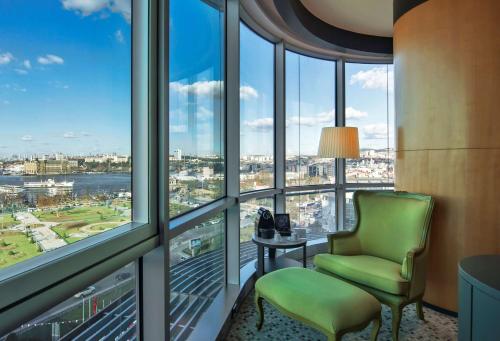 a room with a green chair and windows at DoubleTree By Hilton Istanbul - Moda in Istanbul