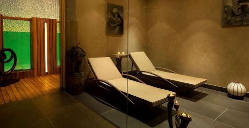 two white chairs in a room with a window at DoubleTree By Hilton Istanbul - Moda in Istanbul