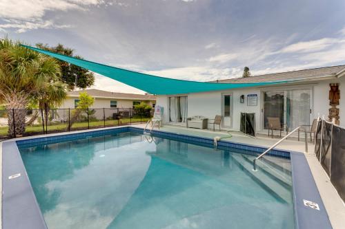 a swimming pool with a blue canopy over a house at Heated Pool Canal-Front Rotonda West Retreat in Rotunda-West