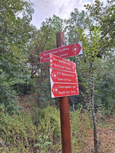 a wooden sign with arrows on a wooden pole at Vila Vera in Vršac