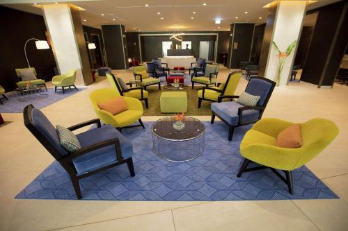 a lobby with chairs and tables and a waiting room at Doubletree By Hilton Pointe-Noire City Centre in Pointe-Noire