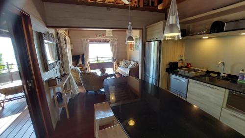 a kitchen with a counter top and a living room at Villa Honu - Legends Residences - Stunning Ocean Views in Papetoai