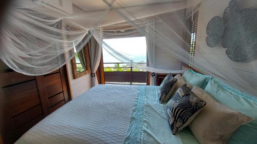 una camera con letto a baldacchino in barca di Villa Honu - Legends Residences - Stunning Ocean Views a Papetoai