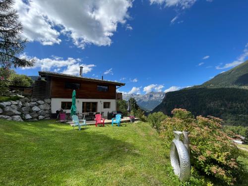 a house in the mountains with chairs in the yard at Amazing View appartement du Chalet in Les Houches