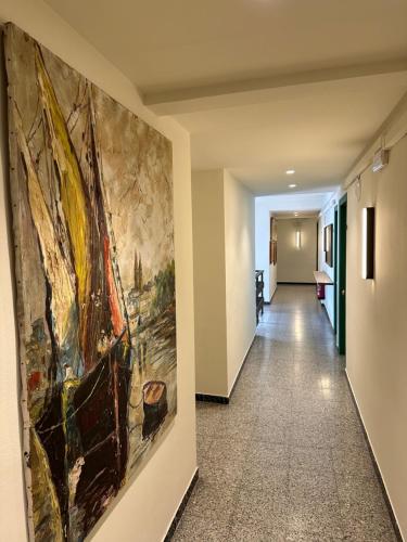 a hallway with a painting on the wall at L'Illa Hotel in Tossa de Mar