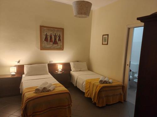 a hotel room with two beds and a bathroom at B&B Casa Cosmano in Brancaleone Marina