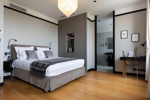 a bedroom with a large bed and a chandelier at Hôtel Restaurant le Touring - Teritoria in Saint-Raphaël