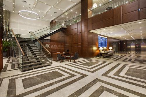伊斯坦堡的住宿－伊斯坦布爾阿弗希拉爾希爾頓逸林酒店，大堂设有楼梯和桌椅