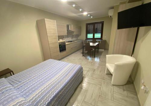a bedroom with a bed and a kitchen with a table at Agriturismo I 3 Fratelli in Sala Consilina